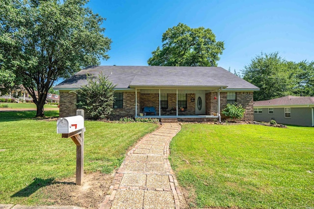 ranch-style home with a porch, a front lawn, and brick siding