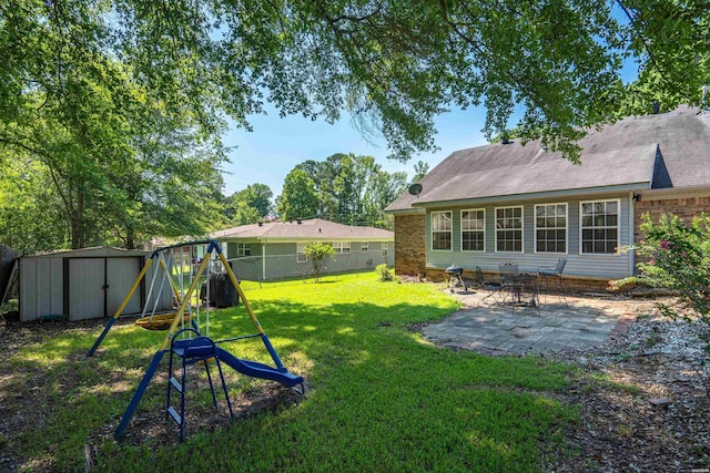 view of yard with an outbuilding, a playground, a patio area, a shed, and a fenced backyard