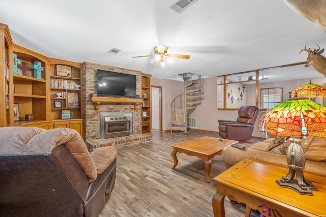 living area featuring light wood-type flooring, visible vents, and stairway