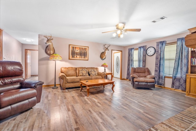 living area featuring light wood-style flooring, visible vents, ceiling fan, and baseboards