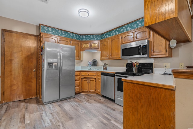 kitchen with stainless steel appliances, brown cabinets, and light countertops