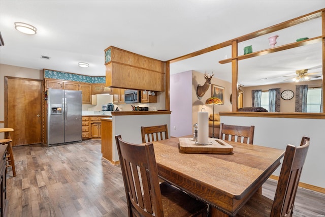 dining space featuring ceiling fan, light wood-type flooring, and visible vents