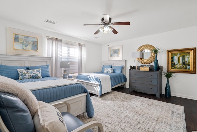 bedroom with visible vents, baseboards, dark wood-type flooring, and a ceiling fan