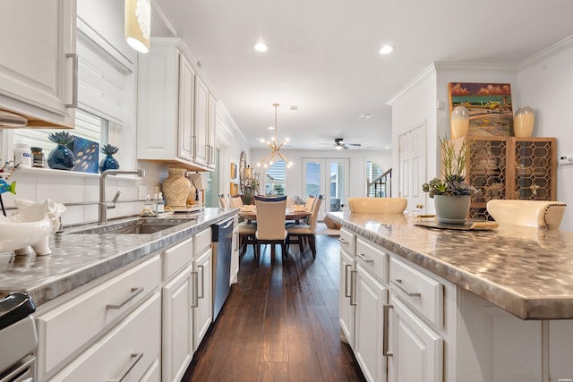 kitchen with ornamental molding, dishwasher, white cabinets, and a sink