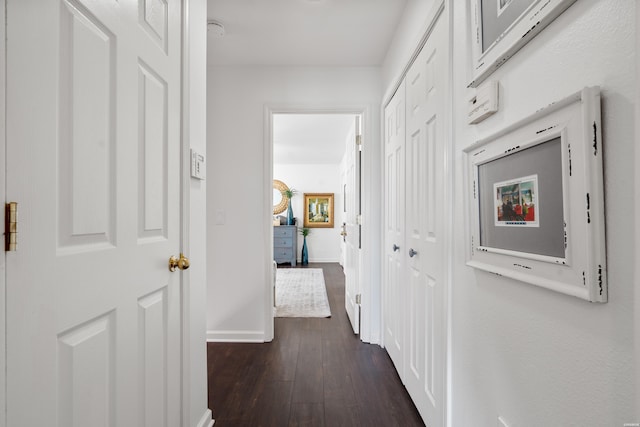 hall with baseboards and dark wood-type flooring