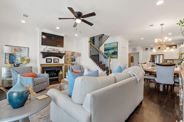 living area featuring visible vents, crown molding, ceiling fan with notable chandelier, recessed lighting, and dark wood-style floors