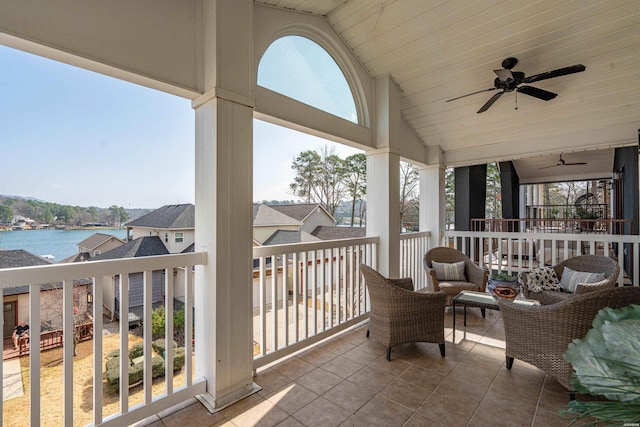 balcony featuring a ceiling fan and a water view