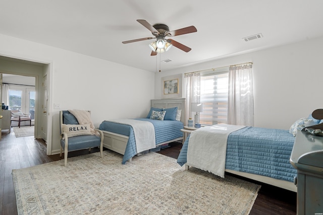 bedroom with visible vents, baseboards, ceiling fan, and wood finished floors