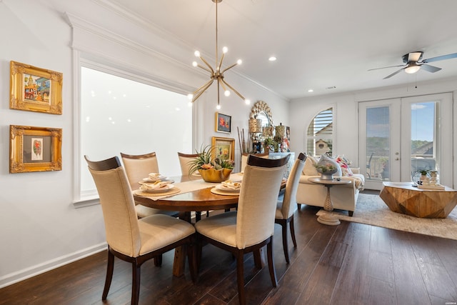 dining space with dark wood-type flooring, ornamental molding, ceiling fan with notable chandelier, french doors, and baseboards