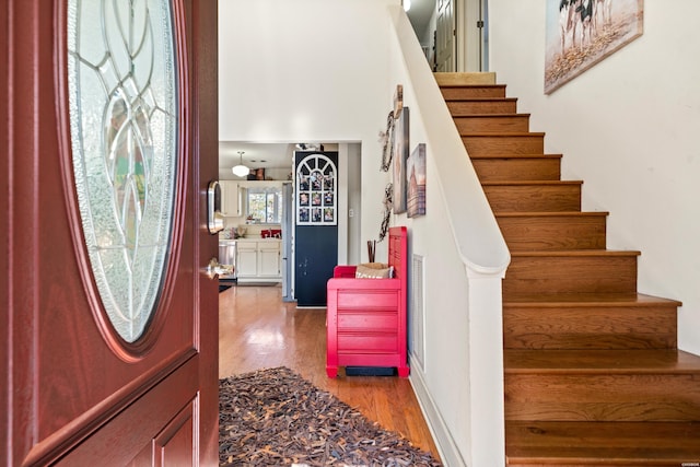 foyer entrance with light wood finished floors and stairs