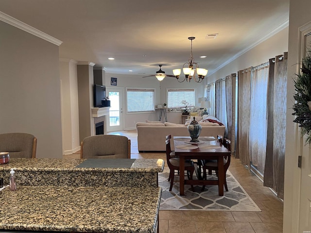 dining area featuring visible vents, a tiled fireplace, crown molding, a notable chandelier, and recessed lighting