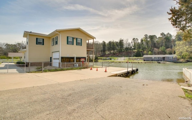 130,133,150 Treasure Isle Road, Hot Springs, AR 71913 - exterior space featuring fence, a water view, stucco siding, an attached garage, and a boat dock