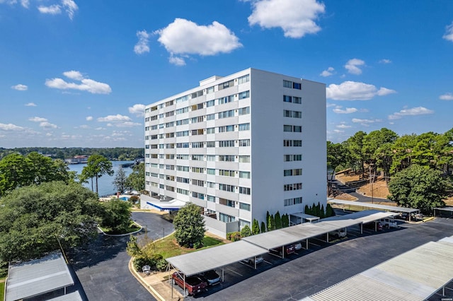 view of building exterior with covered parking and a water view