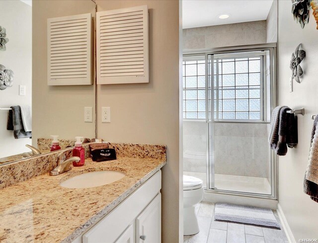 bathroom featuring toilet, a stall shower, and vanity