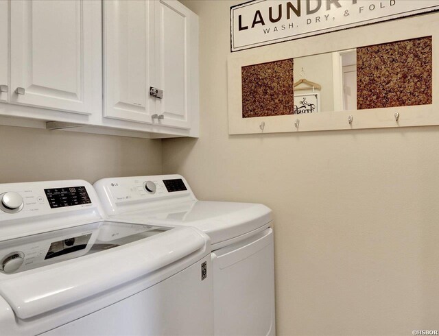 washroom featuring washer and clothes dryer and cabinet space