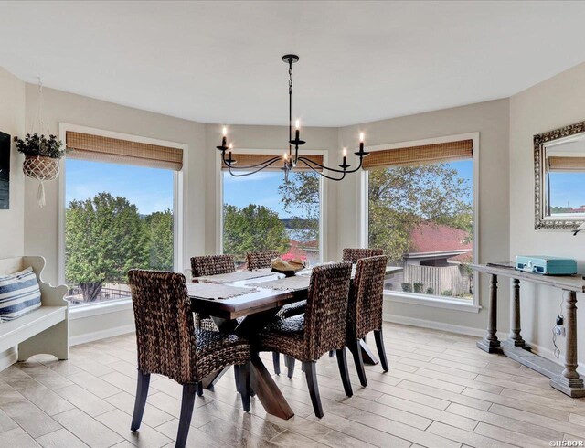 dining room with a chandelier, light wood finished floors, and baseboards