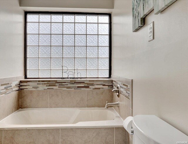 bathroom with toilet and a bath