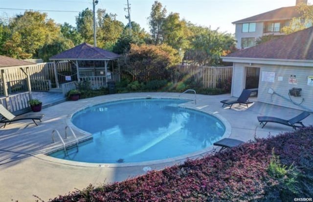 view of swimming pool featuring a fenced in pool, a patio area, fence, and a gazebo