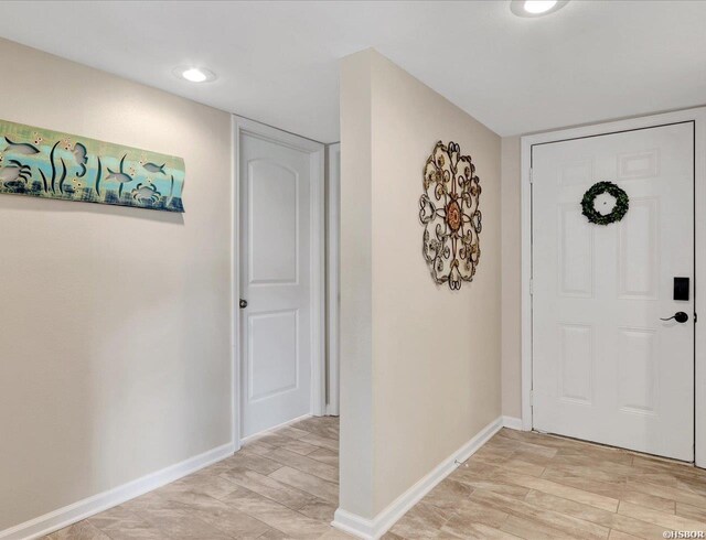 foyer entrance featuring recessed lighting, light wood finished floors, and baseboards