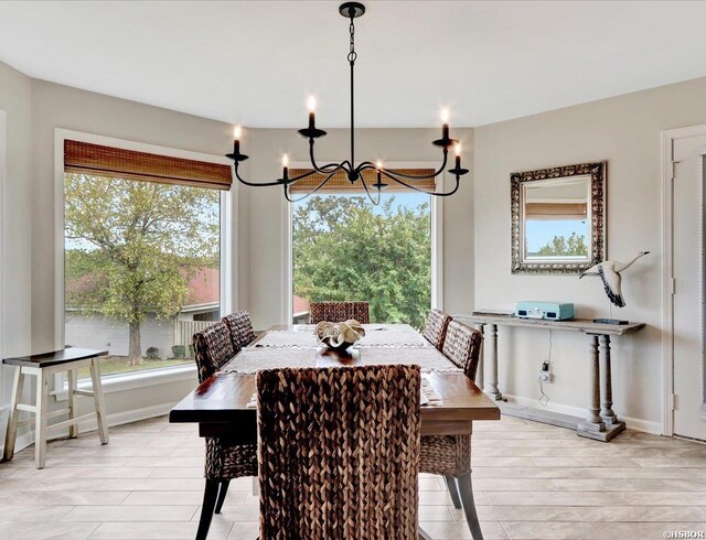 dining area featuring light wood-type flooring, baseboards, a chandelier, and a wealth of natural light