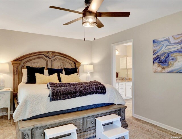 bedroom featuring a ceiling fan, ensuite bath, and baseboards