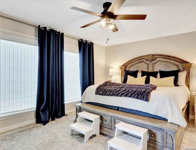 bedroom with ceiling fan and baseboards