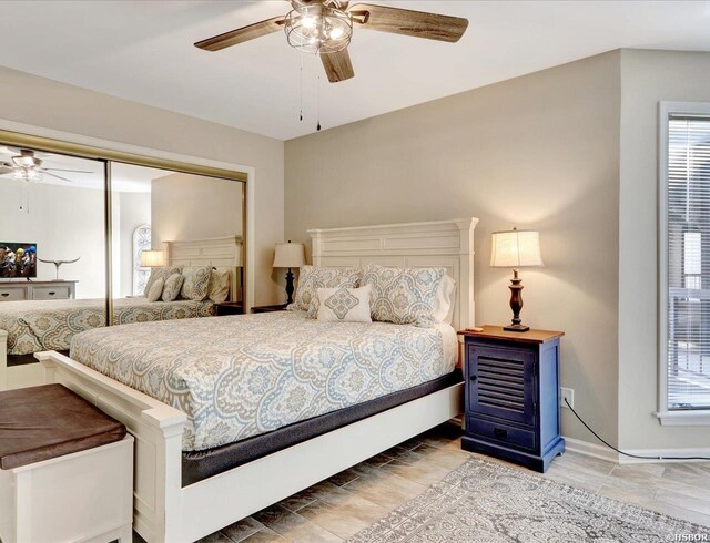 bedroom with multiple windows, a closet, a ceiling fan, and baseboards