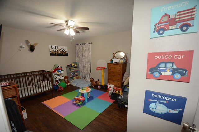 playroom with dark wood finished floors and ceiling fan