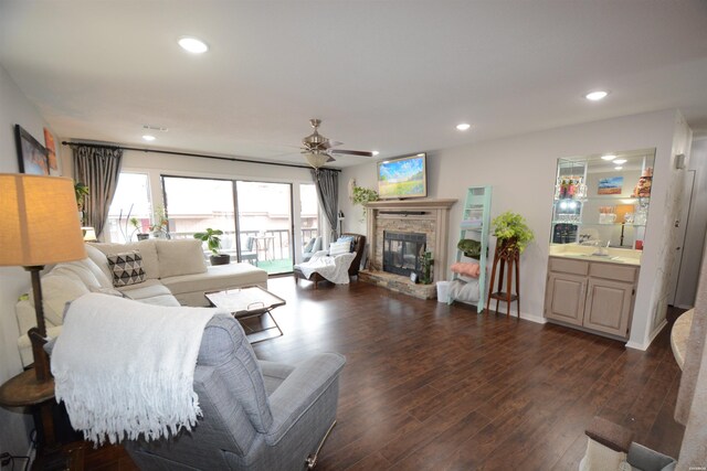 living room with ceiling fan, dark wood-type flooring, a fireplace, and recessed lighting