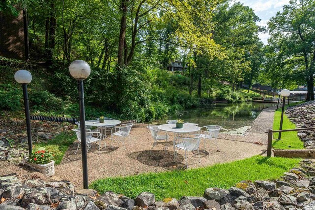 exterior space featuring a patio area, a water view, and outdoor dining area