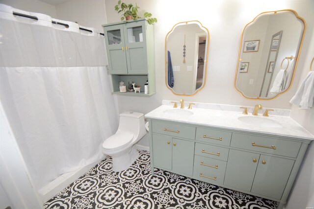 full bathroom with double vanity, a sink, toilet, and tile patterned floors