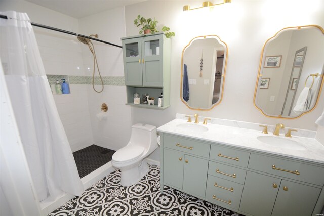 bathroom with a tile shower, a sink, toilet, and tile patterned floors