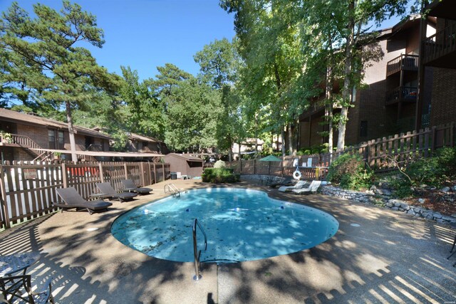 pool with fence and a patio