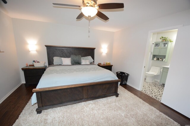 bedroom featuring dark wood-style floors, connected bathroom, baseboards, and a ceiling fan