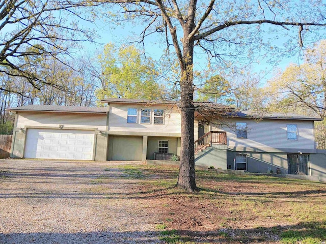 view of front of property featuring stairway, driveway, and an attached garage