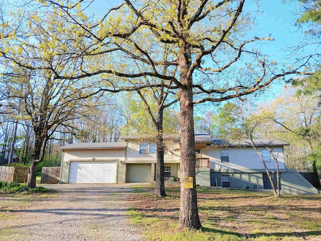 view of front of house featuring driveway, fence, and a garage