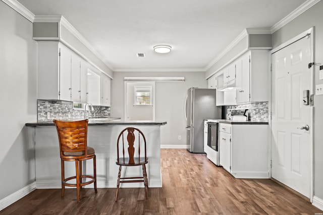 1204 Marion Anderson Rd, Hot Springs, AR 71913 - kitchen featuring white electric range oven, wood finished floors, a peninsula, backsplash, and crown molding