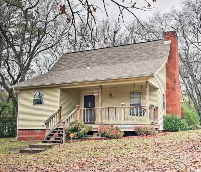 view of front of home with roof with shingles, a porch, crawl space, and a chimney