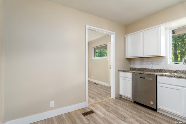 kitchen with light wood finished floors, visible vents, stainless steel dishwasher, white cabinetry, and backsplash