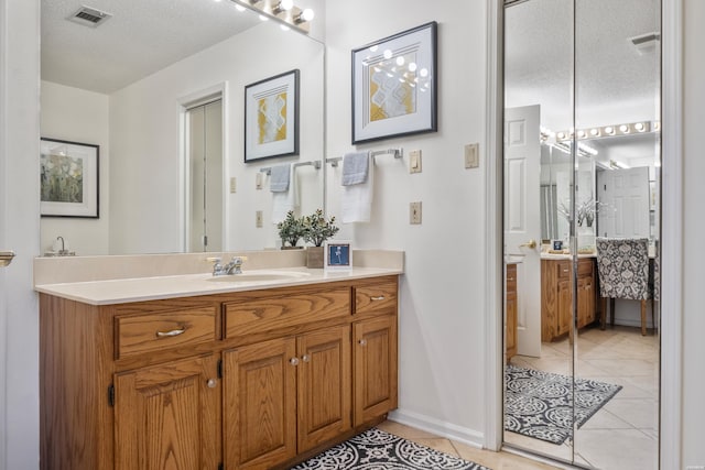 bathroom with a textured ceiling, tile patterned flooring, and visible vents