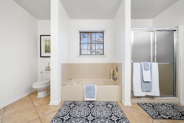 bathroom with baseboards, toilet, a garden tub, tile patterned flooring, and a textured ceiling