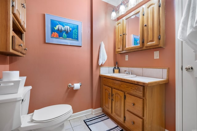 half bathroom with vanity, tile patterned flooring, toilet, and baseboards