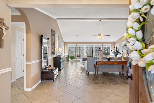 living room featuring light tile patterned floors, arched walkways, a ceiling fan, vaulted ceiling, and crown molding