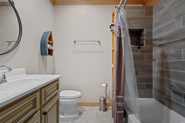 bathroom featuring baseboards, toilet, tile patterned flooring, shower / bath combo with shower curtain, and vanity