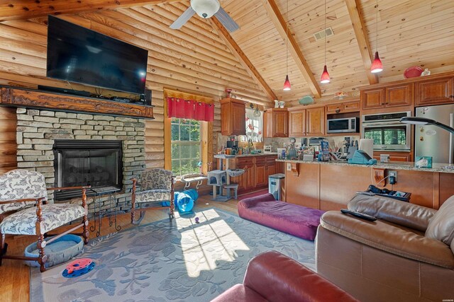 living room featuring light wood-style floors, wood ceiling, beam ceiling, and a stone fireplace