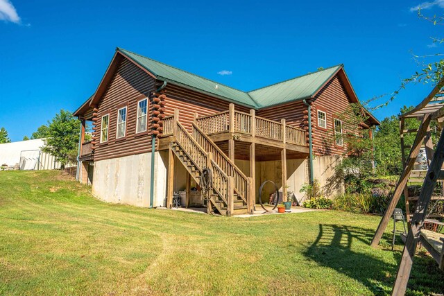 rear view of house with stairway, a lawn, log siding, and a wooden deck