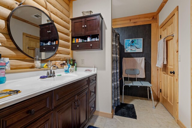 bathroom featuring log walls, visible vents, vanity, and baseboards