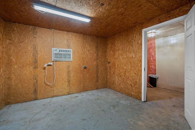 interior space featuring unfinished concrete flooring and a wall mounted AC