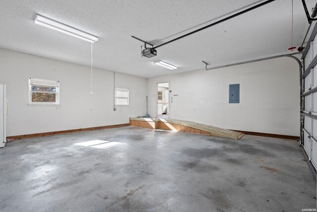 garage featuring baseboards, freestanding refrigerator, electric panel, and a garage door opener