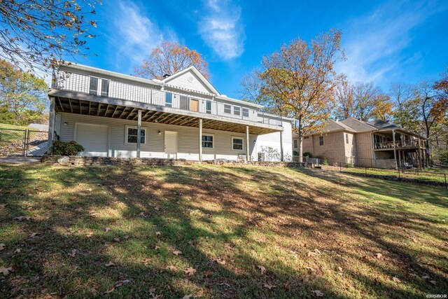 back of property featuring a yard, fence, and a garage